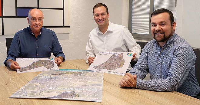 unter anderem Sebastian Kirchmann (Geschäftsführer Stadtwerke Schwerte) und Dimitrios Axourgos (Schwerter Bürgermeister) an einem Tisch mit Karten zur Quartierentwicklung Schwerterheide und Egste-Ost