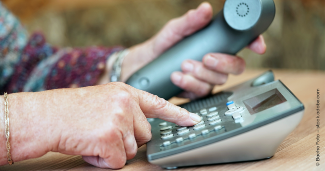 Person wählt Nummer auf Tastentelefon als Symbol für kostenfreie Anrufe