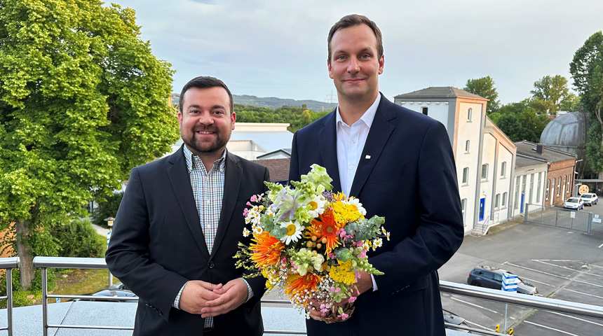 Bild von Dimitrios Axourgos, Bürgermeister der Stadt Schwerte, und Sebastian Kirchmann, Geschäftsführer der Stadtwerke Schwerte, der einen Blumenstrauß hält   