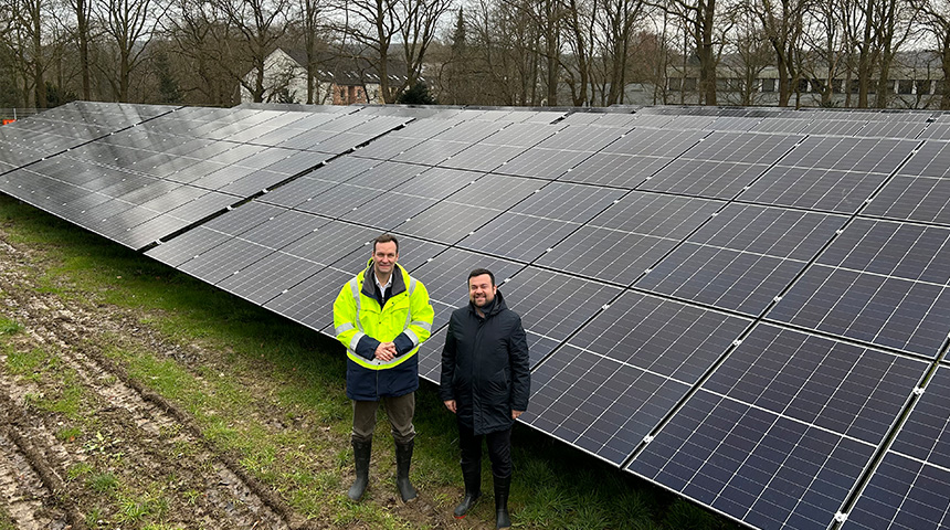 Stadtwerkegeschäftsführer Sebastian Kirchmann (l.) und Aufsichtsratsvorsitzender Dimitrios Axourgos stehen vor einem großen Solarpanel auf der Solaranlage an der Ostberger Straße.